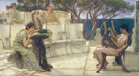 Painting. To our left, four people sit in two rows of curving, marble seats in an outdoor amphitheatre. One person stands next to a seated woman at the front centre, and a sixth person, to our right, leans back in a wood chair, playing a lute. All the people have pale or tanned skin, and wear voluminous, pleated robes in pastel shades of blue, green, pink, and yellow. A glimmering body of deep sapphire blue is beyond the structure.